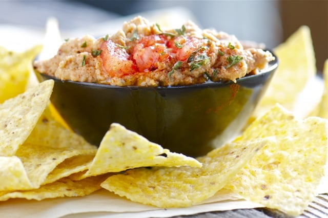A Tasty Southwestern Hummus by Namely Marly Corn tortilla chips surround a bowl of hummus prepared with southwestern spices